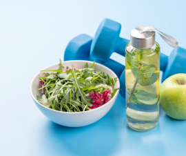 bowl of vegetables, water bottle and hand weights